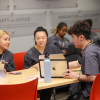 Student chat while working on laptops