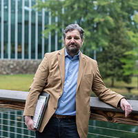 Andy Eckert standing on boardwalk with office building in the background