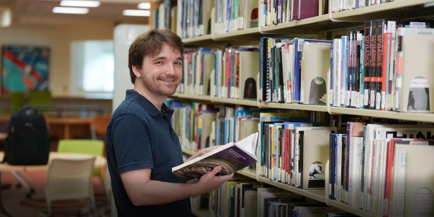 Oliver Salter reading a book in the library