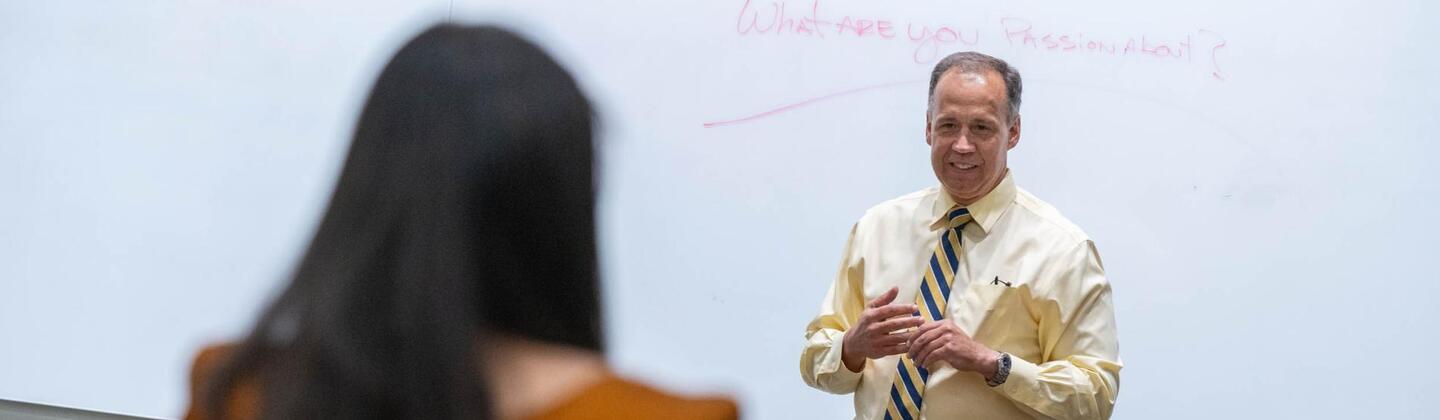 Professor talking in front of a white board