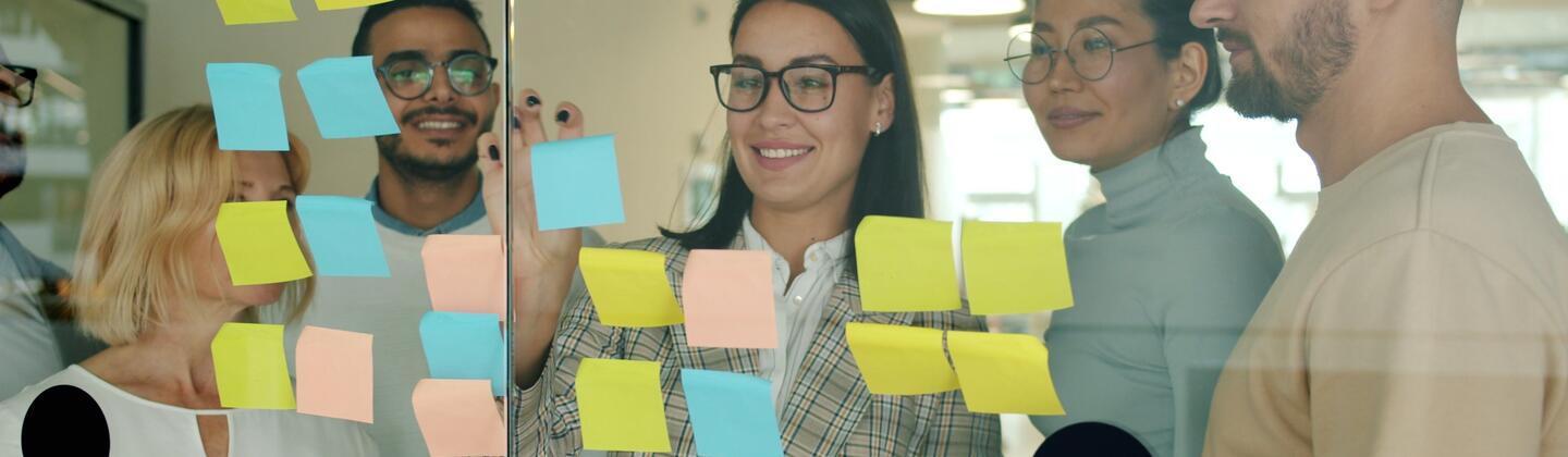 Picture of five people reviewing a kanban board