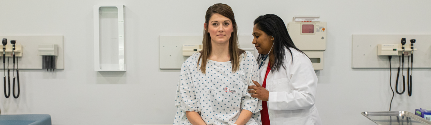 Doctor in white coat listens to a patient's heart