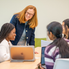 Professor helping students in a classroom